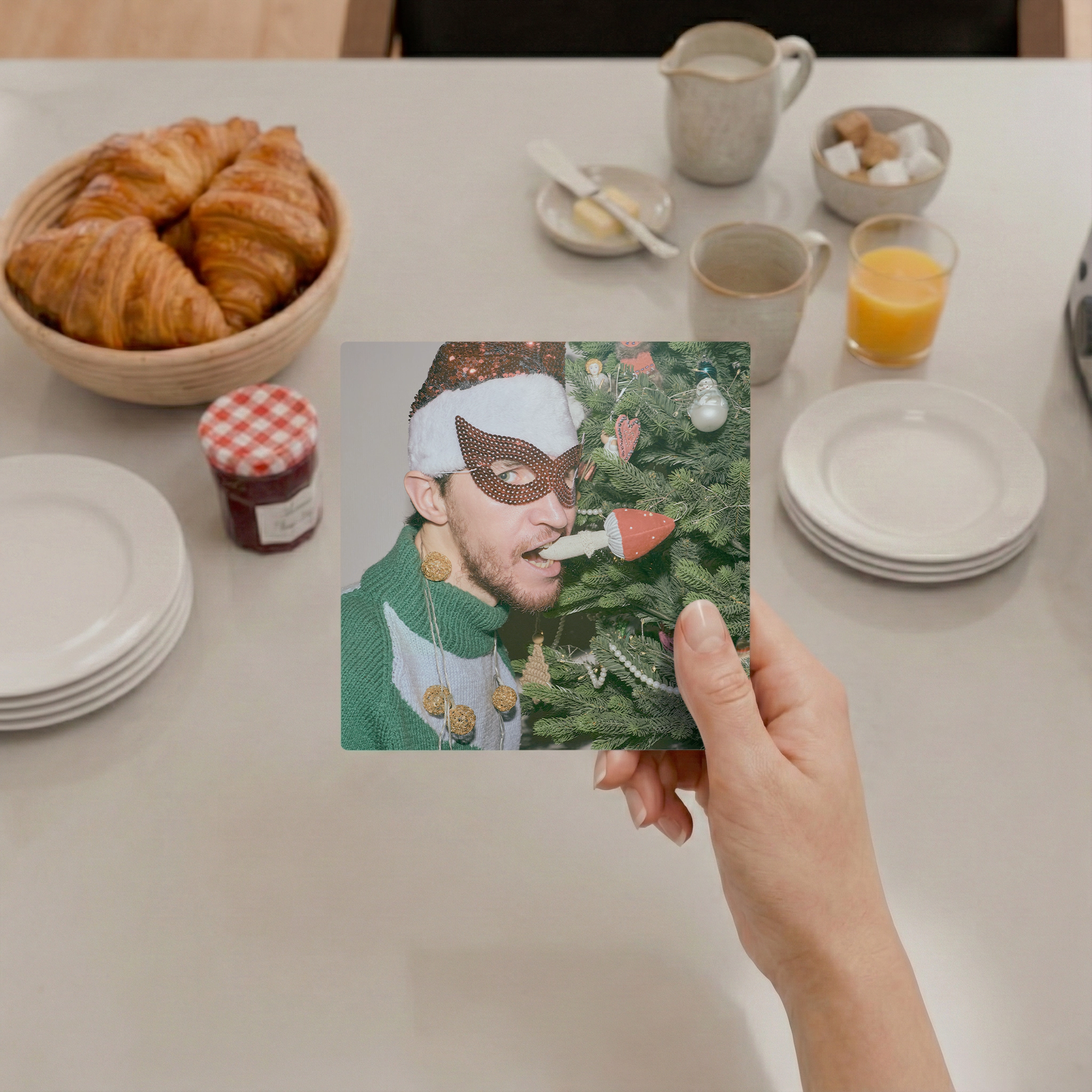 Hand holding an Imagelet photo above a breakfast table