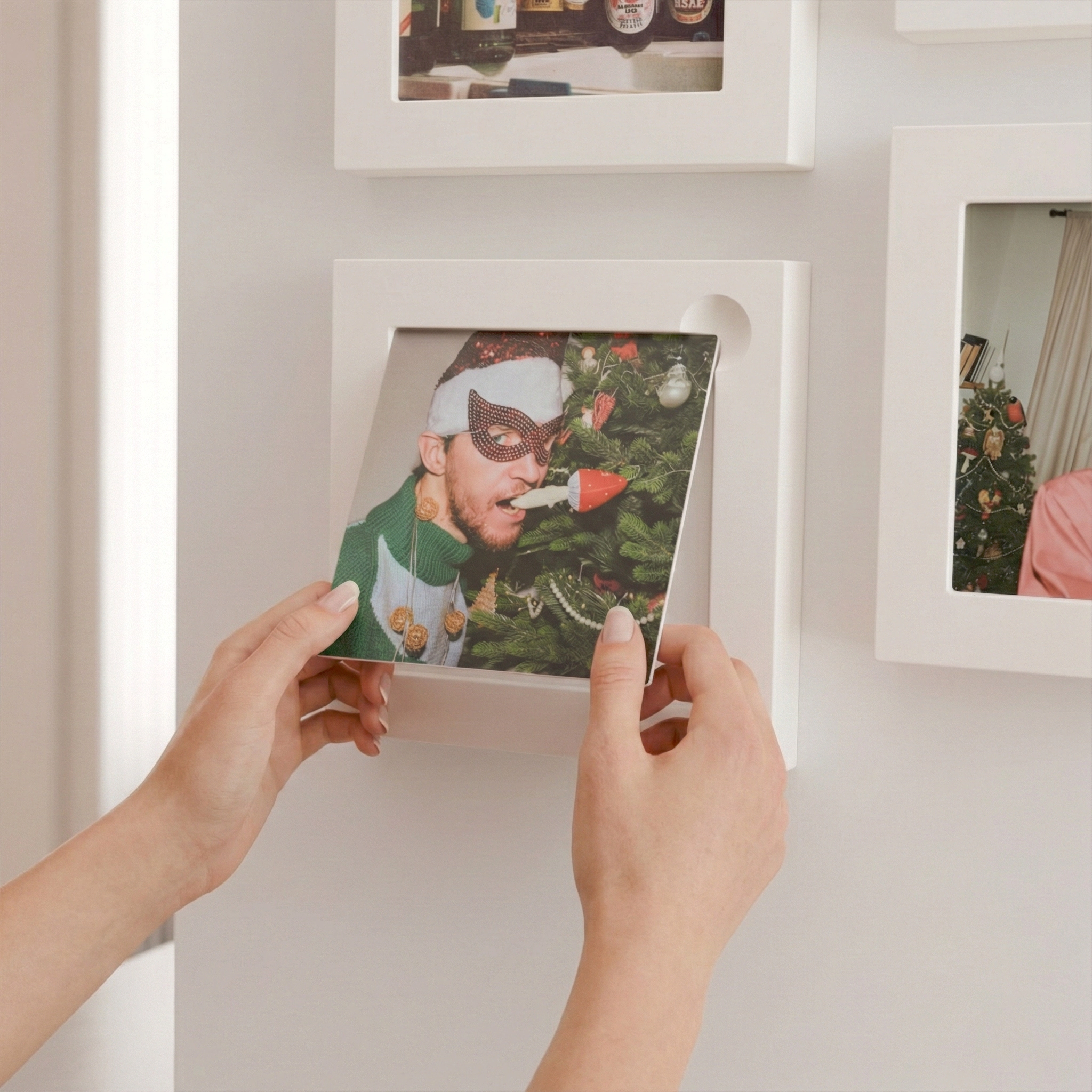 Hands swapping an Imagelet print in a wall-mounted frame